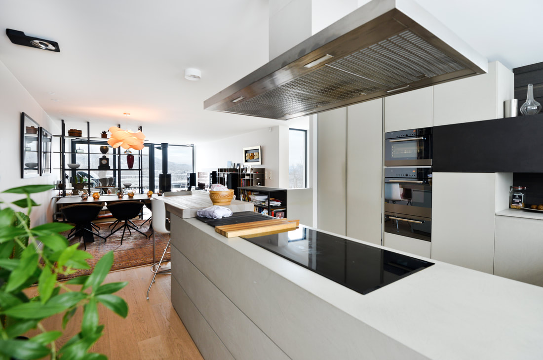 Hvitt kjøkken i stilrent design med kjøkkenøy i Bleikerhaugen