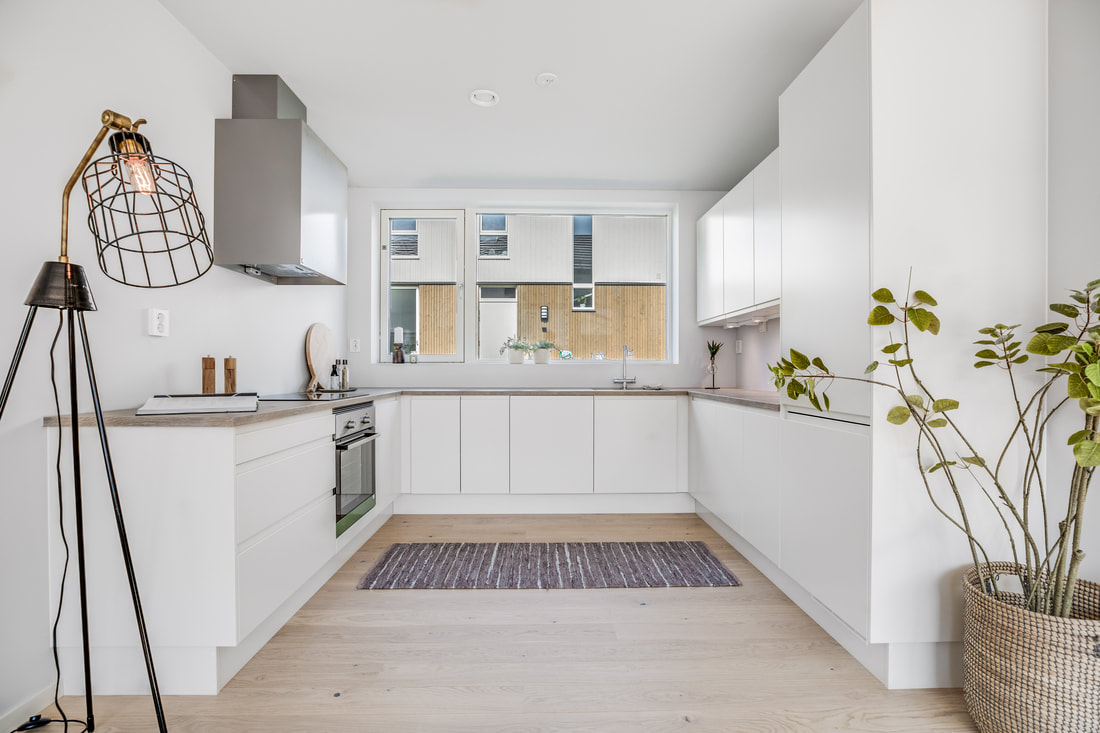 Stort U kjøkken med moderne lampe og glatte flater i Bringebærhagen