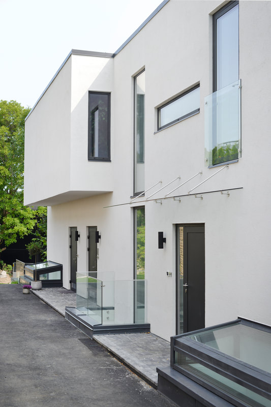Inngang i moderne stil og glass rekkverk på arkitekttegnet bolig i Oslo