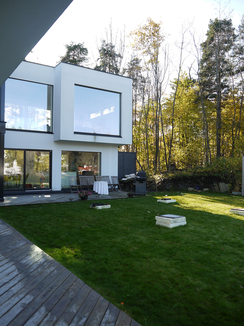Moderne arkitektur med terrasse i plan med plen i Bærum