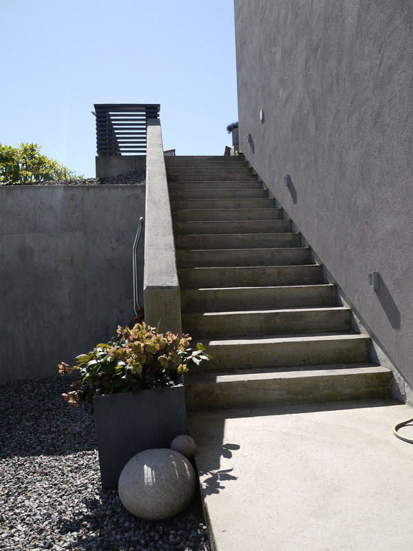 Utvendig trapp i betong på arkitekttegnet mur hus i Asker